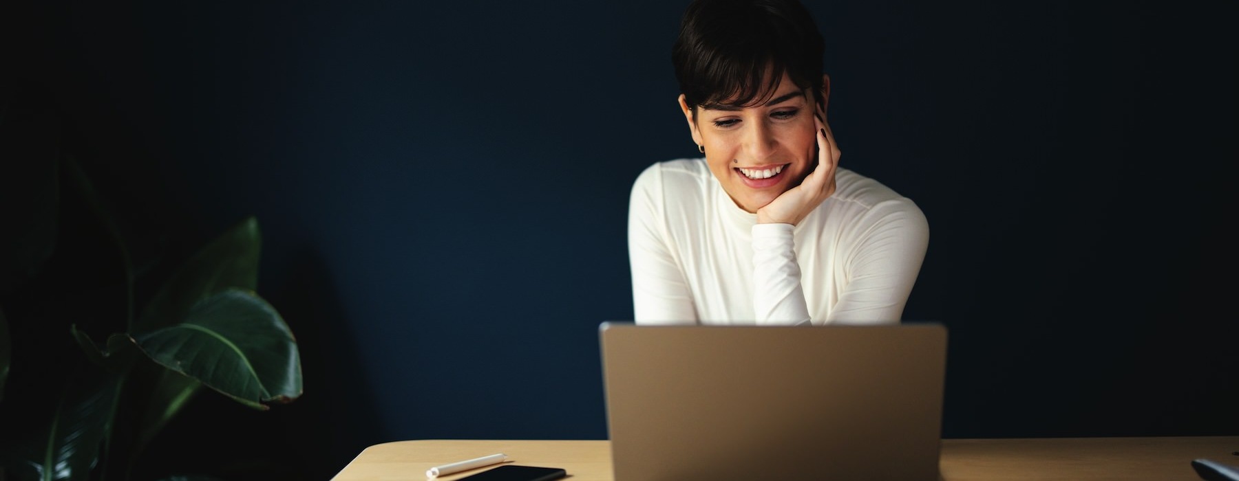 a woman sitting at a table with a laptop